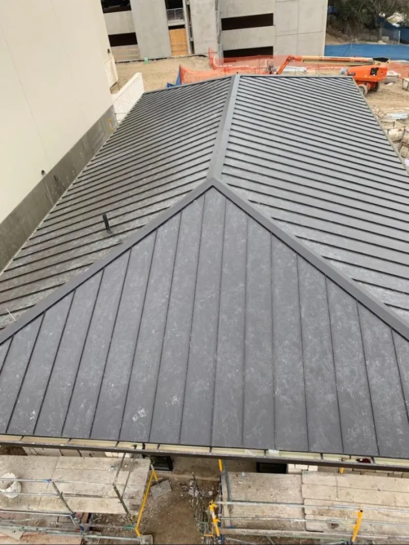Commercial metal roof construction with crane equipment in Oswego